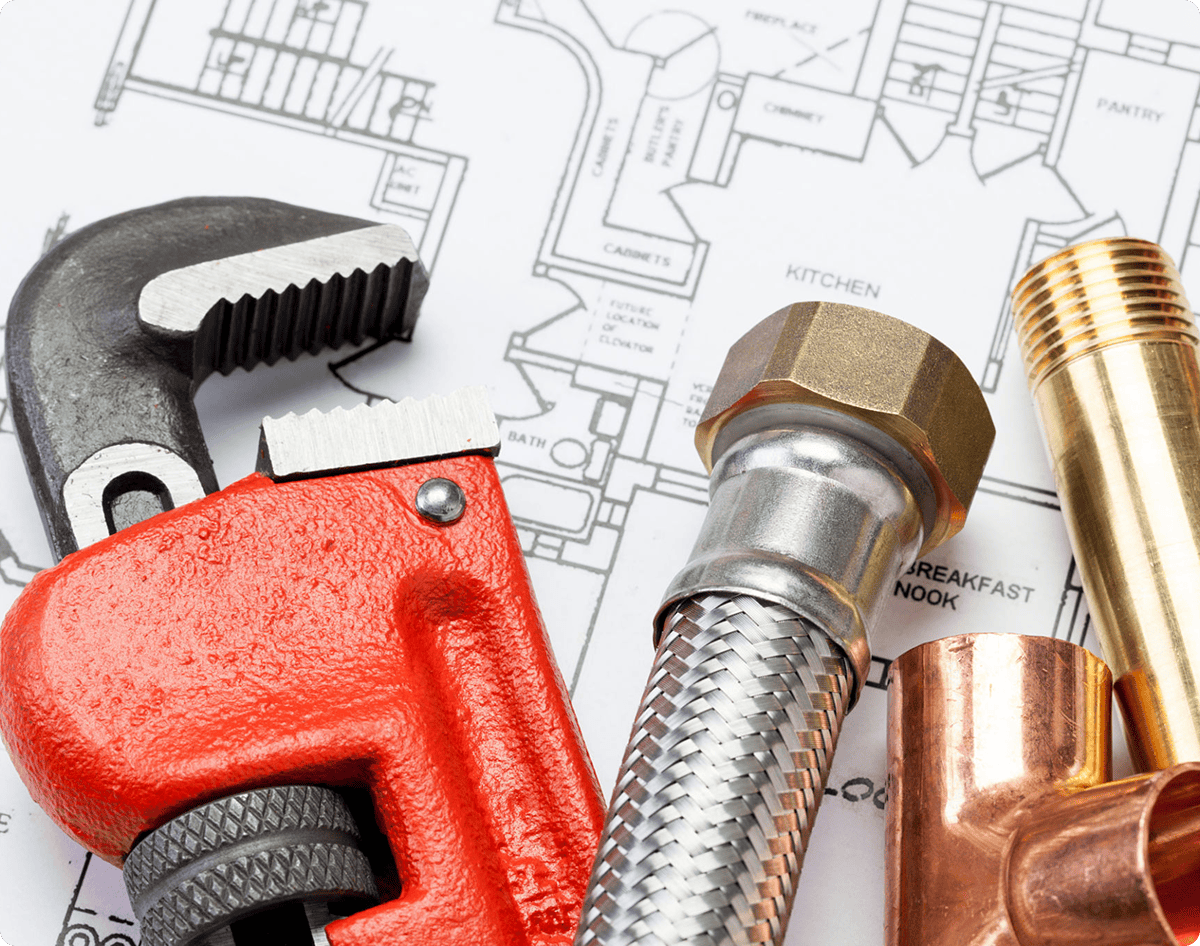 Plumbing tools on architectural blueprint