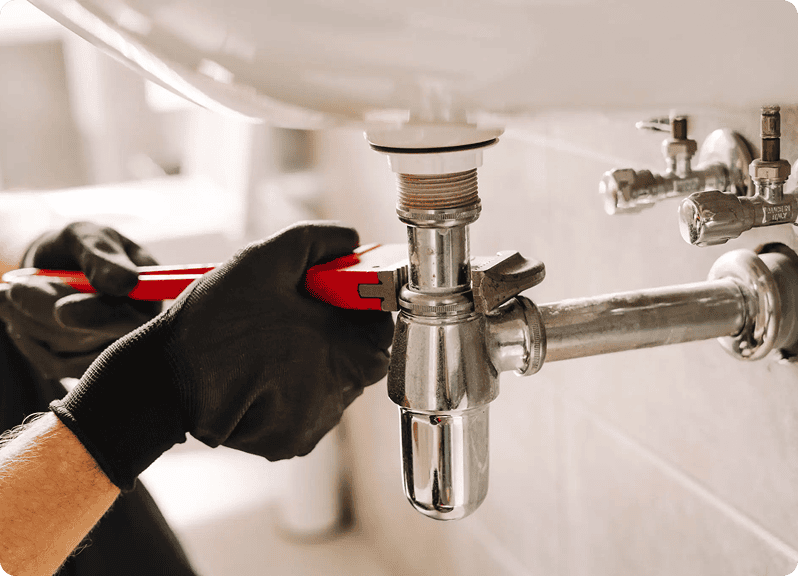 Plumber fixing sink pipe with wrench