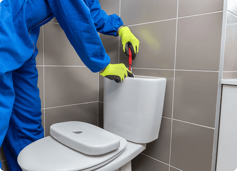 Technician using tools on toilet system